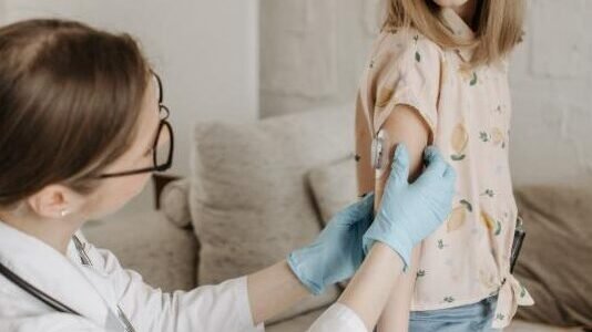 Doctor administering MMR vaccination to a young girl